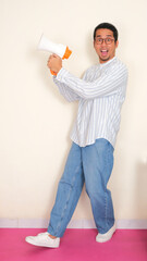 Full body portrait of a man holding megaphone with excited expression