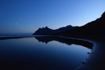 A beautiful night sky with a full moon reflecting on the water