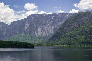 A tranquil alpine lake against the backdrop of mountains with green forest