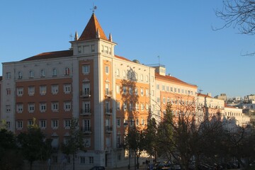 Naklejka premium Historic building in Lisbon with a clear sky, showing classic architecture and warm sunlight.