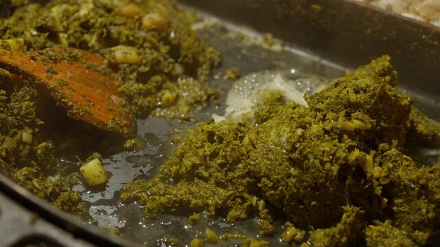 Slow Motion of cooking and making kale next to cham in a very big pan with onions and potatos. Making kale with potatoes and onions in a very big pan