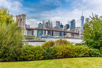 A view past undergrowth towards the Brooklyn bridge and Manhattan in New York, in the fall
