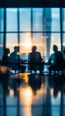 Silhouetted business meeting at sunset with reflections in modern office building