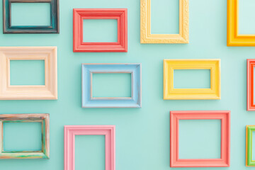 Colorful picture frames arranged on a vibrant teal background wall.