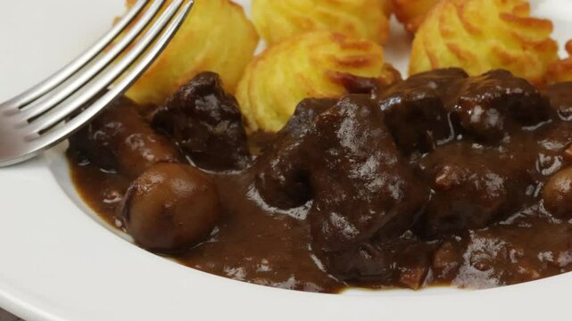 boeuf bourguignon et pommes de terre duchesse, en gros plan, dans une assiette