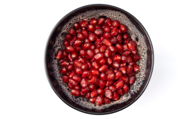 Gennevilliers, France - 01 02 2024: Close up of a gray and white clay bowl filled with red triangular pomegranate seeds on a white background.