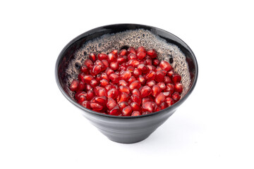 Gennevilliers, France - 01 02 2024: Close up of a gray and white clay bowl filled with red triangular pomegranate seeds on a white background.
