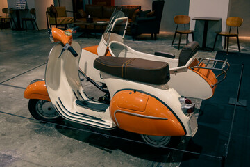 old orange and white sidecar motorcycle on display in gallery