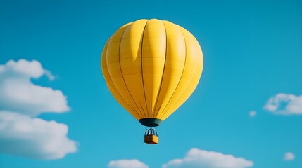 Fototapeta premium Vibrant Yellow Hot Air Balloon Soars Against a Clear Blue Sky with Fluffy White Clouds Creating a Picturesque Scene of Adventure and Freedom