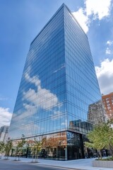 Sleek skyscraper reflects clouds, showcasing modern architecture