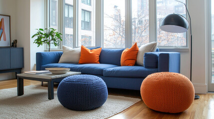  Cozy modern living room with a blue couch, orange pillows, and natural lighting from large windows, symbolizing comfort and contemporary design.