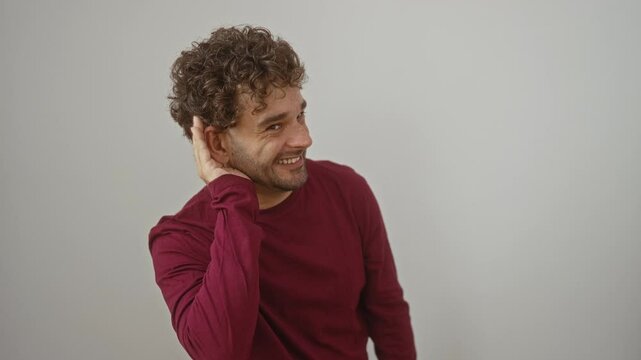 Man listening to rumor, young hispanic man standing with hand over ear, wearing t-shirt, hearing gossip over isolated white background, exploring deafness, deaf awareness, communication