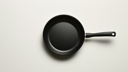 Black frying pan on white background, top view, ready for cooking.