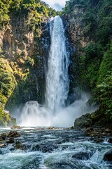 Fototapeta premium Majestic waterfall cascading down rocky cliffs, surrounded by lu