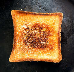 A piece of fried bread in a pan. Fried toast. Square Bread - toast in a pan. a golden slice of...