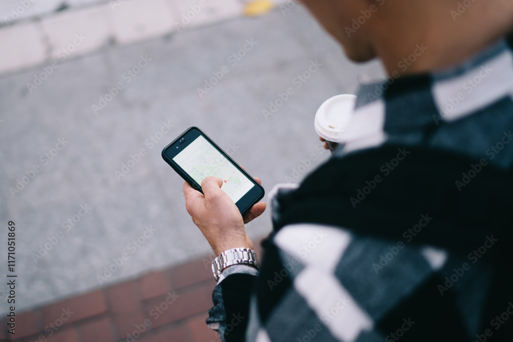 Poster cropped image of male standing on street using mobile phone online navigation app for walking, top v