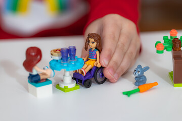 Obraz premium Closeup of kid playing LEGO Friends