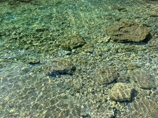 Pebbles and stones in crystal clear sea water.