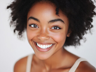 A close-up shot of a joyful young woman with a big smile against a soft background.