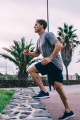 Serious male athlete stepping outdoors training legs muscle strength and cardio energy reaching...