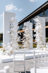 Wedding luxury arch. White flowers under the sunlight at restaurant