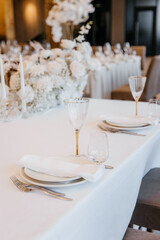 Decorating a hall for an expensive luxury wedding in a restaurant with lights, flowers, and seating details for guests