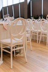 Decorating a hall for an expensive luxury wedding in a restaurant with lights, flowers, and seating details for guests
