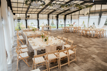Decorating a hall for an expensive luxury wedding in a restaurant with lights, flowers, and seating details for guests