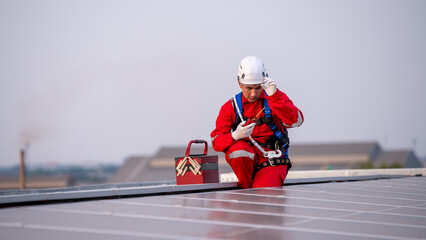 Engineers walking on roof inspect and check solar cell panel by hold equipment box and radio...