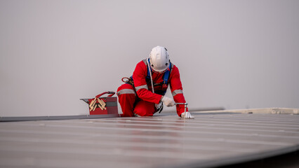 Engineers walking on roof inspect and check solar cell panel by hold equipment box and radio...