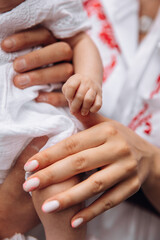 Baby holding mother's finger close-up photo. Parental support and help for newborns