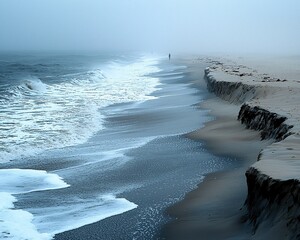 Solitary figure on foggy beach with eroding shoreline and waves.