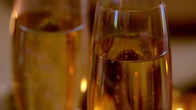 vid&eacute;o sur deux coupes de champagnes, &eacute;clairage &agrave; la bougie, pour une ambiance de f&ecirc;tes et de partages, plan vid&eacute;o avec zoom arri&egrave;re