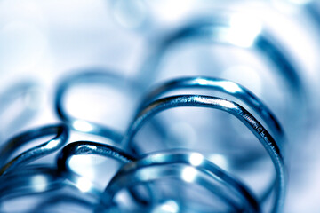 Abstract Close up of Metal Coil Spring Spiral Industrial Blue Background