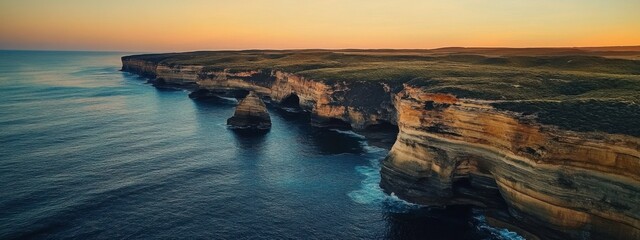 A breathtaking aerial perspective of rugged sea cliffs and natural arches along the dramatic coastline of Australia at sunrise, Australian coastal cliffs scene, Cinematic style