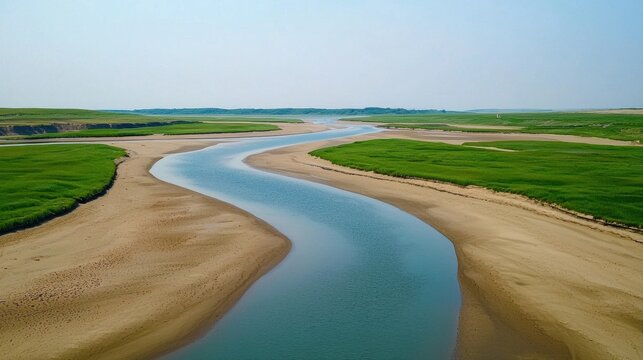 Winding River Flowing Through Lush Green Fields and Marshes in Picturesque Countryside Landscape