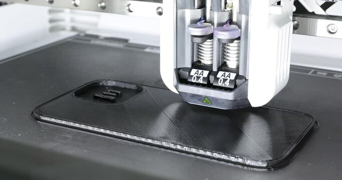 4k movie of a 3D printer, prints a case for a mobile phone. Modern technical 3D printing, new technology. Selective focus.