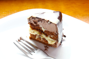 Chocolate cake. Piece of cake on the white plate with fork.
