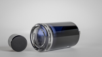 A bottle of perfume with a cap on top. The bottle is blue gradient glass premium photo 3d render