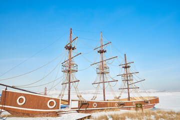 Vintage sailboat moored on frozen lake in winter