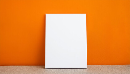 Naklejka premium Mock-up of blank white poster on orange wall background. Empty canvas.