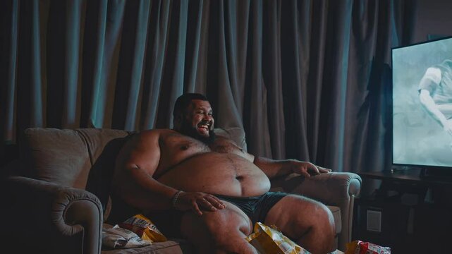 Carefree man indulging in snacks while watching TV