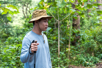 Hiker man with hiking poles in nature park