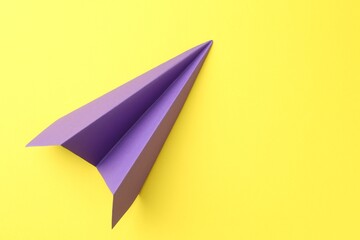 One handmade purple paper plane on yellow background, top view. Space for text