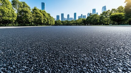 A stunning view of a modern city skyline featuring impressive skyscrapers and a deserted asphalt road beneath a clear blue sky