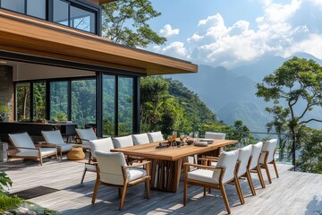 Fototapeta premium Modern outdoor dining table with teak top and white chairs, set against mountain view with greenery, clear blue sky, and serene atmosphere.
