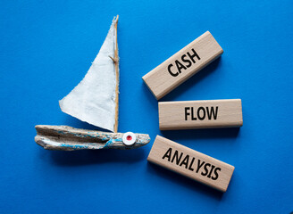 Cash Flow Analysis symbol. Concept words Cash Flow Analysis on wooden blocks. Beautiful blue background with boat. Business and Cash Flow Analysis concept. Copy space.