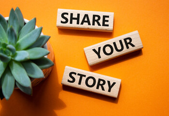 Share your story symbol. Wooden blocks with words Share your story. Beautiful orange background...