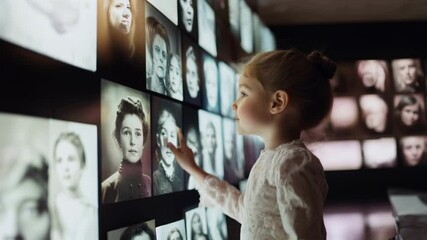 little girl looks at a large screen on which historical photos of famous women are displayed