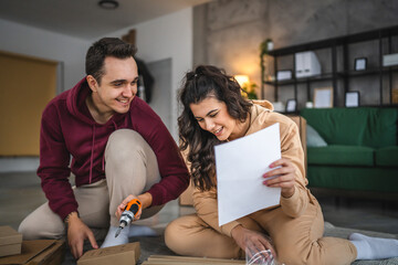 young couple moving in new apartment carry assembly furniture